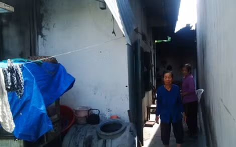 Bà Sáu bên ngôi nhà đơn sơ của mình.
