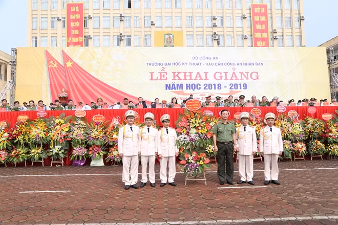 Thiếu tướng Bùi Minh Giám tặng hoa cho Ban giám hiệu nhà trường