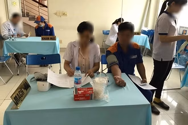 Bà Ngân đo huyết áp cho người lao động