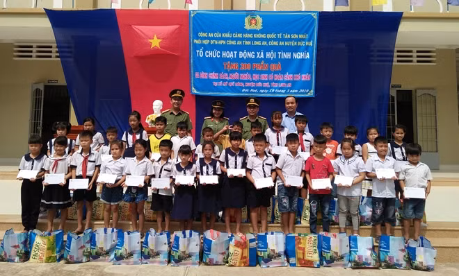 Thượng tá Trần Văn Dũng trao tặng quà cho các gia đình chính sách và học sinh nghèo.