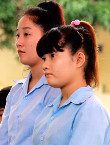 Hai nữ bị cáo tuổi vị thành niên Lê Thị Lài và Lê Thị Huyền tại tòa.
