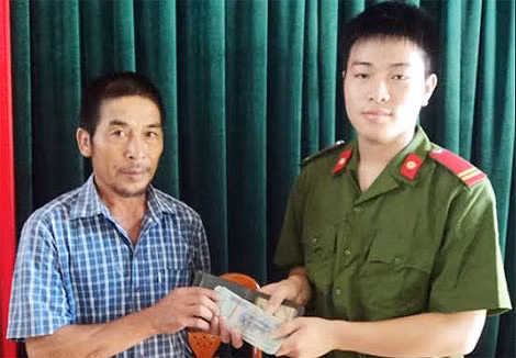 Hạ sỹ Hồ Văn Anh đang trả lại tiền cho ông Hòa (Ảnh: Đài truyền hình Đô Lương)