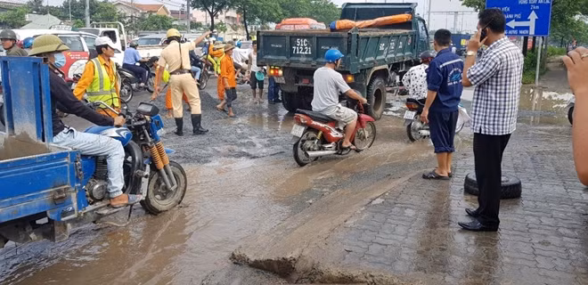 CSGT và người dân cùng tham gia lấp mặt đường hư hỏng