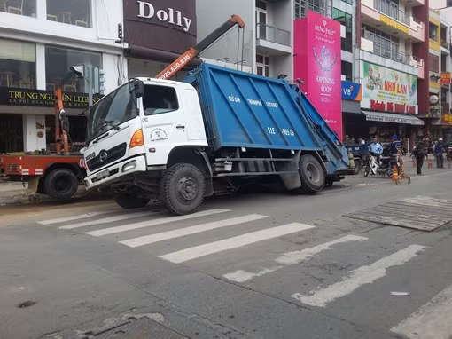 Xe rác lọt bánh xuống “hố tử thần”, giao thông ùn ứ