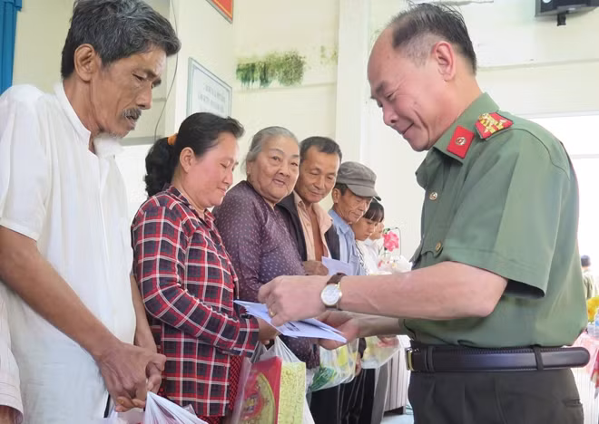 Đại tá Trần Kim Thẩm - Phó Tổng biên tập Báo CAND trao quà cho bà con ăn Tết