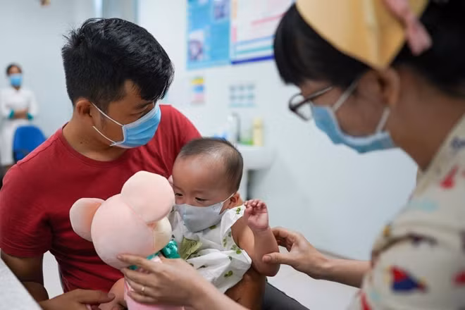Bác sĩ đưa gấu bông cho bé chơi