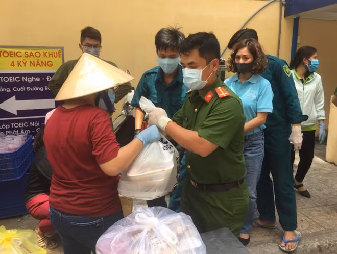 Công an phường đưa đồ ăn vào cho cư dân