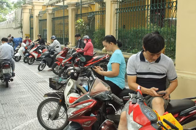 Phụ huynh đứng bên ngoài điểm thi đợi con thi