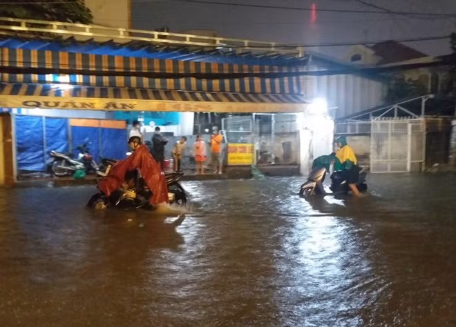 Người dân TP Hồ Chí Minh vất cả dẫn xe chết máy do mưa lớn ngập đường