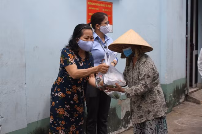 Chi hội trưởng Chi hội luật sự thuộc Hội Bảo vệ quyền trẻ em TP Hồ Chí Minh phát quà cho người dân có hoàn cảnh khó khăn
