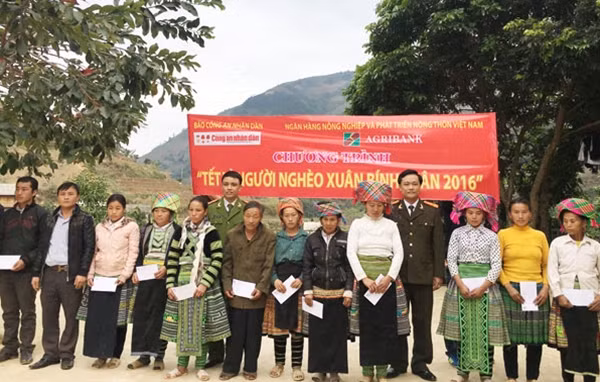 Đại diện Báo CAND, Công an huyện Trạm Tấu và Ngân hàng Agribank tặng quà Tết cho bà con nghèo xã Pá Hu.