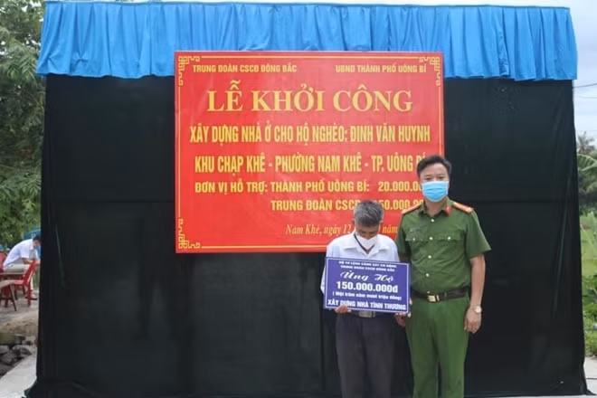 Thượng tá Phùng Toàn Thắng trao số tiền hỗ trợ xây dựng nhà cho gia đình ông Đinh Văn Huynh.