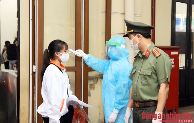 Cán bộ Y tế phường Văn Miếu kiểm tra thân nhiệt cho nữ hành khách.