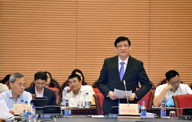 Quyền Bộ trưởng Bộ Y tế Nguyễn Thanh Long trình bày Tờ trình tại phiên họp.