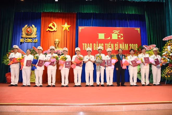 Trung tướng GS.TS Nguyễn Xuân Yêm lên trao bằng cho 12 tân tiến sĩ Học viện CSND năm 2018.