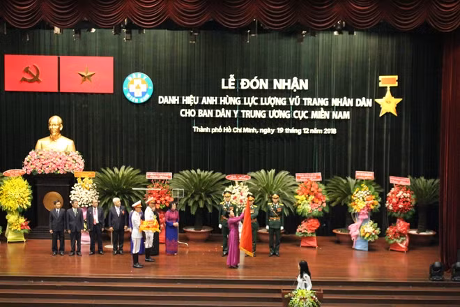 Thừa uỷ quyền của Chủ tịch nước, Chủ tịch Quốc hội Nguyễn Thị Kim Ngân trao tặng và gắn Danh hiệu Anh hùng lực lượng vũ trang Nhân dân lên lá cờ truyền thống của Ban Dân Y Trung ương Cục Miền Nam