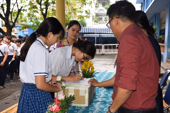 Thí sinh điểm thi THCS Lý Tự Trọng, Gò Vấp kiểm tra niêm phong thùng đề thi.