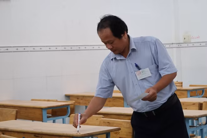 Cán bộ coi thi đánh số báo danh.