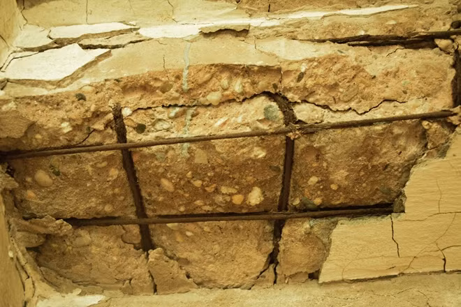 Khung nhà đều nứt toác, lớp vữa bên ngoài, trơ lõi sắt.