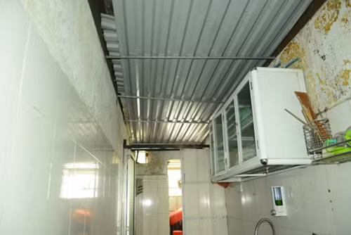 Căn bếp của gia đình anh chị Nguyễn Thị Loan phải dùng tôn che chắn để tránh những tai họa rơi từ trần nhà dột nát.