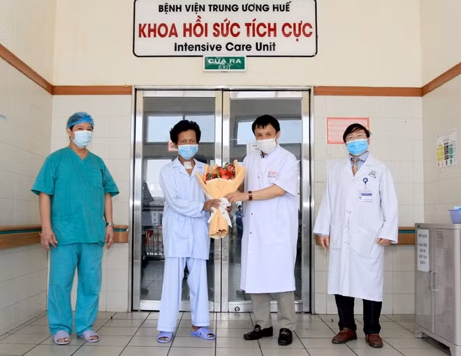 GS.TS Phạm Như Hiệp, Giám đốc Bệnh viện T.Ư Huế tặng hoa chúc mừng bệnh nhân H. xuất viện.