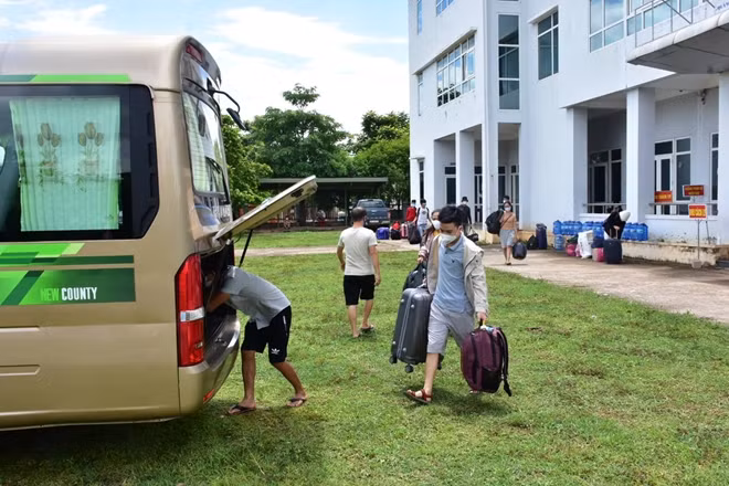 Các công dân tỉnh Thừa Thiên Huế cách ly tại tỉnh Quảng Trị đưa hành lý lên xe ô tô để về tỉnh Thừa Thiên Huế cách ly.