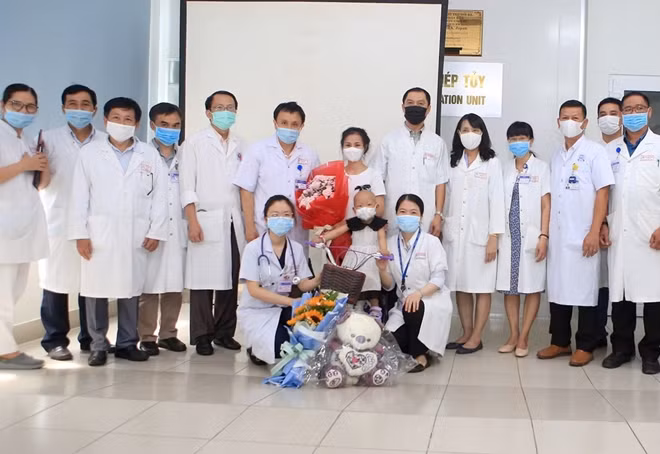 GS.TS Phạm Như Hiệp, Giám đốc Bệnh viện T.Ư Huế cùng các y, bác sĩ tặng hoa chúc mừng cháu Nh. xuất viện.