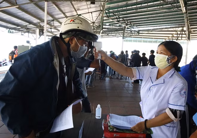 Cán bộ y tế kiểm tra thân nhiệt người đi vào tỉnh Thừa Thiên Huế tại chốt kiểm soát y tế đóng ở huyện Phú Lộc vào tháng 7/2020.