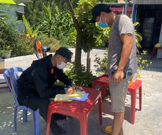 Một tài xế chạy xe tải đường dài khai báo y tế tại chốt kiểm soát.