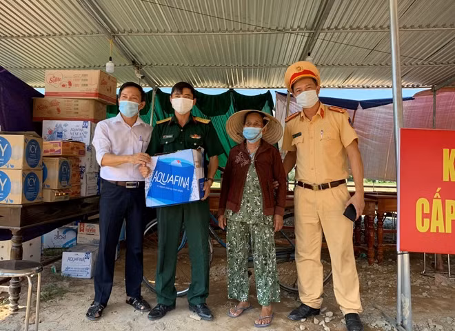 Cụ bà Trần Thị Sừng (87 tuổi, ở xã Phong Thu, huyện Phong Điền) đi xe đạp chở thùng nước suối đến tặng CBCS và các lực lượng làm nhiệm vụ tại chốt giám sát dịch tễ.