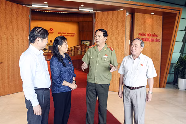 Bộ trưởng Trần Đại Quang trao đổi với các đại biểu bên hành lang Quốc hội.