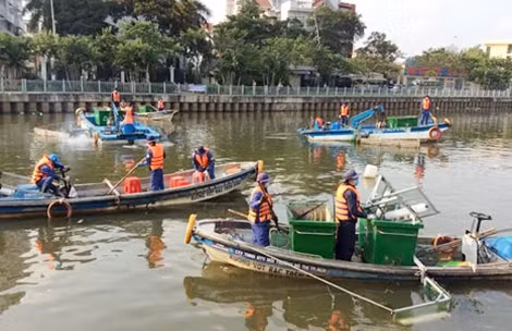 Nhân viên C6ng ty Môi trường đô thị vớt rác trên kênh Nhiêu Lộc.