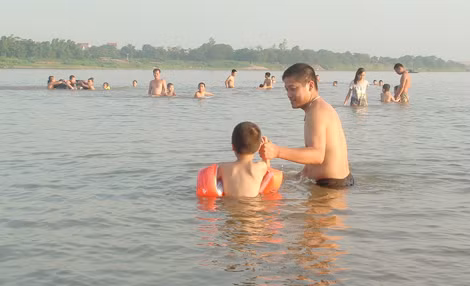 Nắng nóng khiến nhiều người đưa cả gia đình ra sông... giải nhiệt.