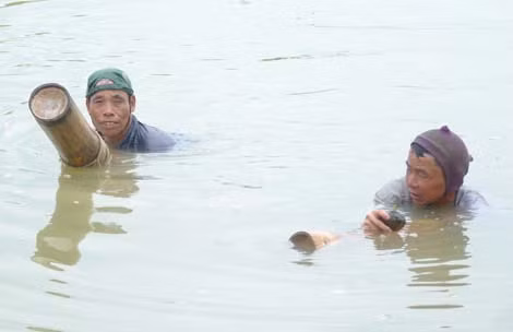 Ông Nguyễn Văn Khải (trái) và anh Đại ngoi lên bám vào khúc bương nghỉ lấy sức để rồi lặn tiếp.