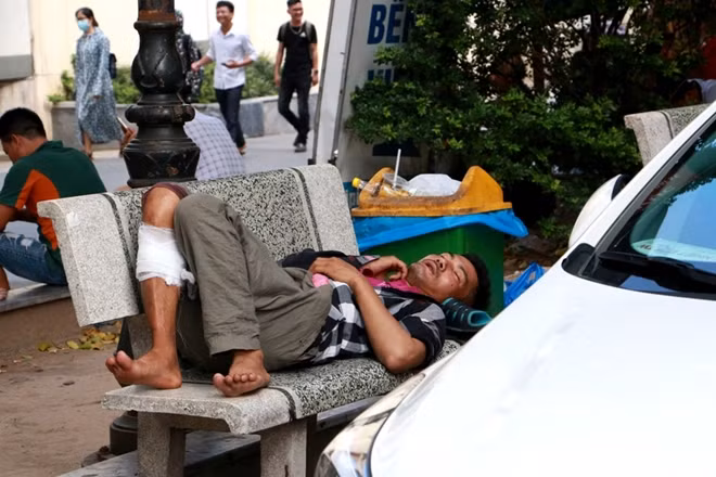 Dưới tiết trời nắng nóng nhiệt độ lên tới 40 độ C đến 45 độ C, người nhà bệnh nhân kiệt sức, mệt lả bất cứ chỗ nào có bóng râm cũng trở thành nơi ngả lưng.