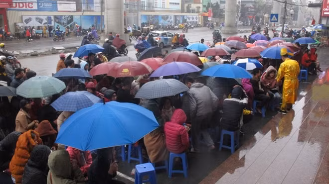 Trước các cửa hàng vàng luôn đông nghịt khách vào ngày này. Tại cửa hàng vàng Bảo Tín Minh Châu trên đường Xuân Thủy (Cầu Giấy, Hà Nội) người dân xếp hàng dài dưới trời mưa để đợi được vào mua vàng vào ngày Vía Thần Tài.