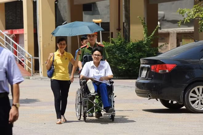 Một sĩ tử mặc dù bị chấn thương chân nhưng vẫn quyết tâm đến điểm thi để hoàn thành bài thi của mình.