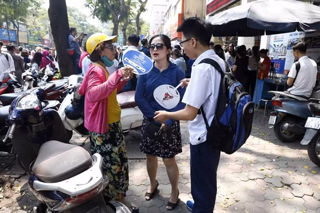 Một học sinh tươi cười khoe với Phụ huynh làm bài rất tốt tại điểm thi THPT Việt Đức.