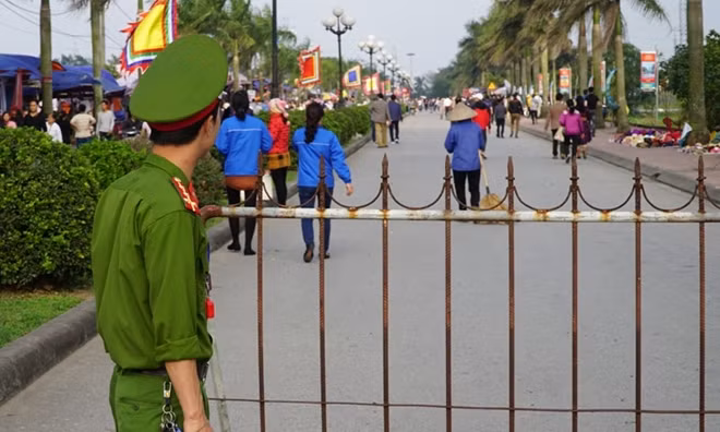 Một chiến sỹ Công an túc trực bảo vệ bên ngoài Đền Trần. Năm nay lễ hội Đền Trần sẽ kéo dài từ 26-2 đến 3-3 dương lịch (tức 11 đến 16 tháng giêng Âm Lịch).