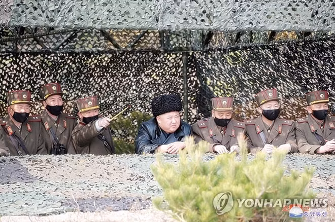 Các quan chức đều đeo khẩu trang khi thị sát tập trận còn ông Kim Jong-un thì không. Ảnh: KCNA