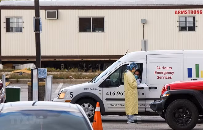 Nhân viên kiểm tra thông tin y tế của người dân tại một điểm xét nghiệm COVID-19 ở Ontario, Canada. Ảnh: Reuters