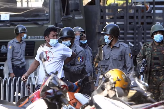 Một người biểu tình bị lực lượng an ninh Myanmar bắt giữ. Ảnh: Reuters
