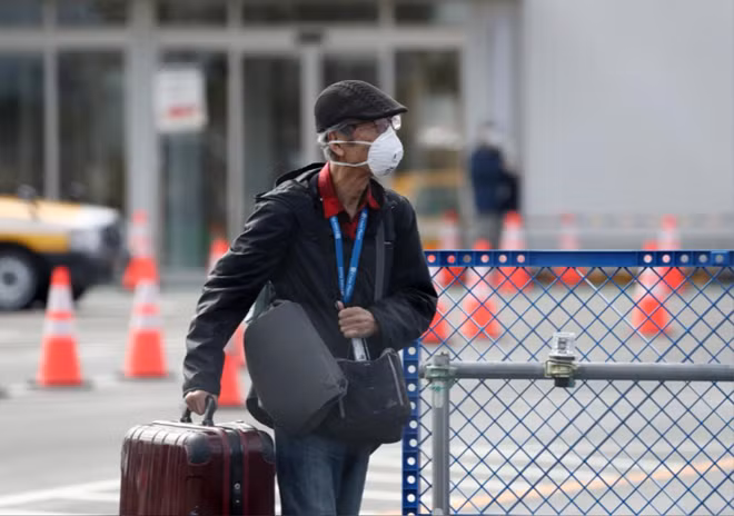Các hành khách được phân phát khẩu trang khi rời tàu. Ảnh: Reuters