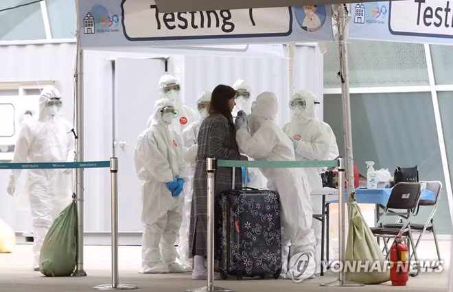 Nhân viên y tế Hàn Quốc lấy mẫu xét nghiệm cho du khách trước khi nhập cảnh. Ảnh: Yonhap