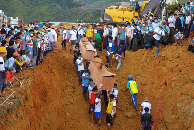 Tình nguyện viên đưa quan tài đến khu mộ tập thể. Ảnh: Reuters