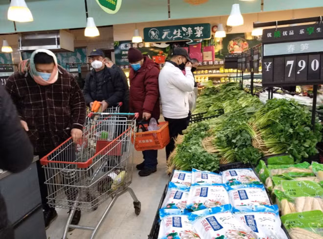 Người dân được khuyến cáo đeo khẩu trang và hạn chế bắt tay để tránh lây nhiễm. Ảnh: Reuters