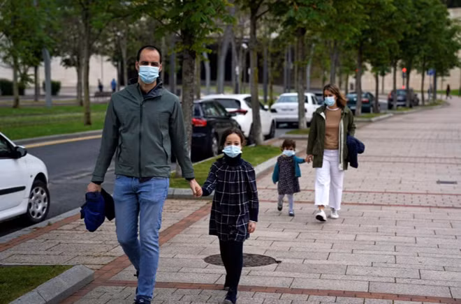2 em bé cùng bố đi dạo trên đường phố Bilbao, Tây Ban Nha sau 6 tuần không được ra ngoài. Ảnh: Reuters