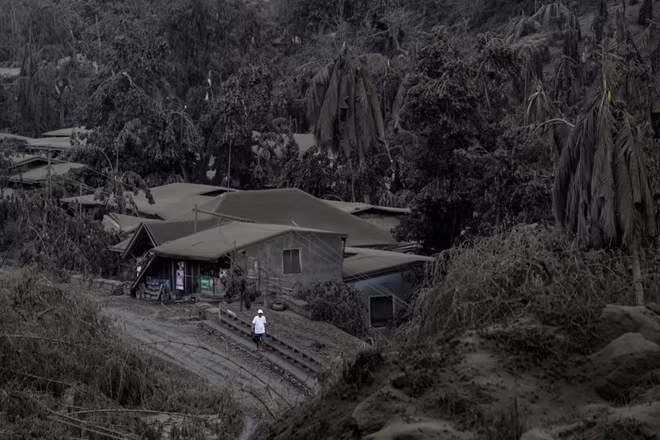 Một làng quê tại Philippines bị nhuộm đen bởi tro bụi khuếch tán từ núi lửa Taal. Ảnh: Reuters