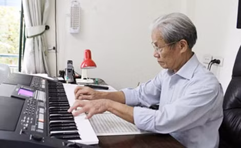 Nhạc sĩ Nguyễn Tài Tuệ bên cây đàn piano của mình.