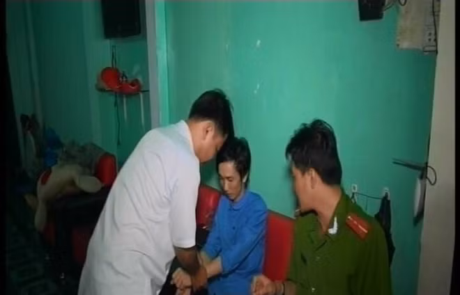 Đối tượng Dân (áo xanh) tại cơ quan Công an